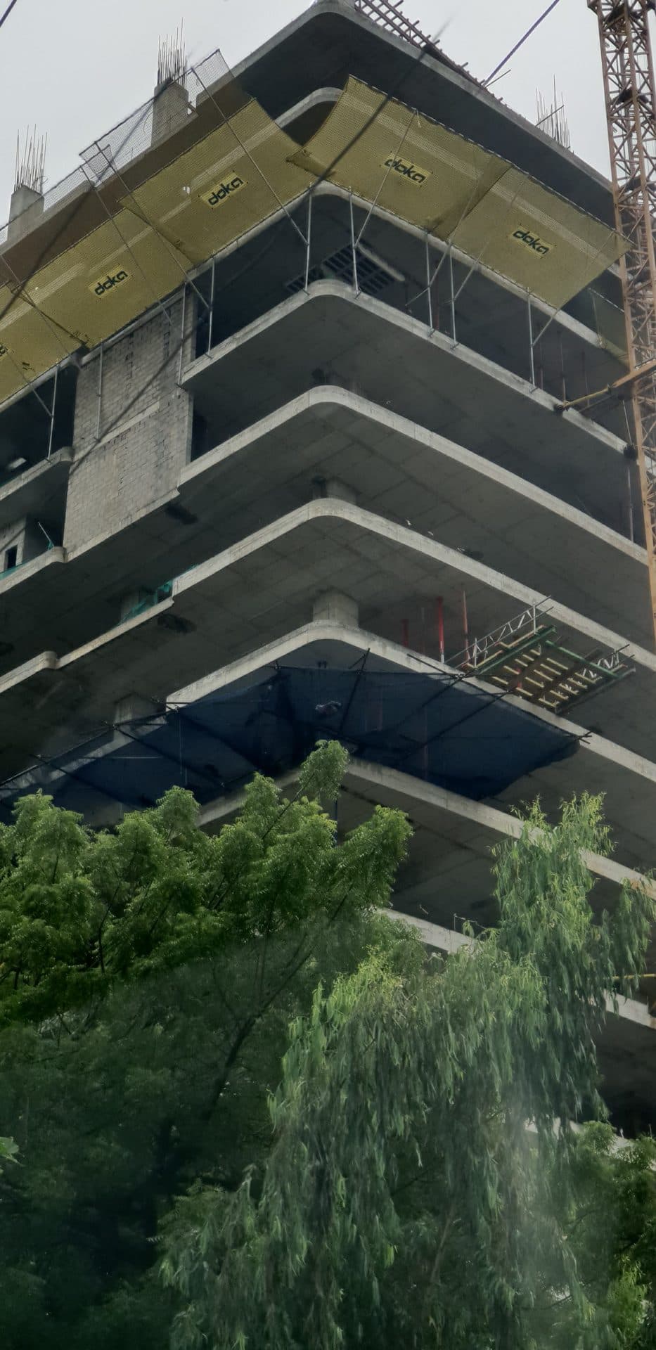 Perimeter fall arrest netting on a high-rise slab edge